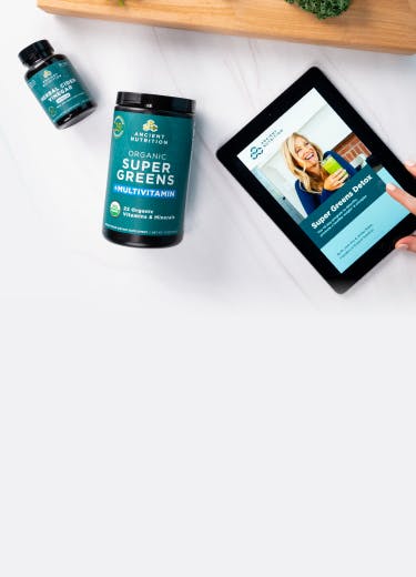 bottle of supergreens next to an ipad