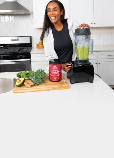 Woman blending up green smoothie with Ancient Nutrition multi collagen protein
